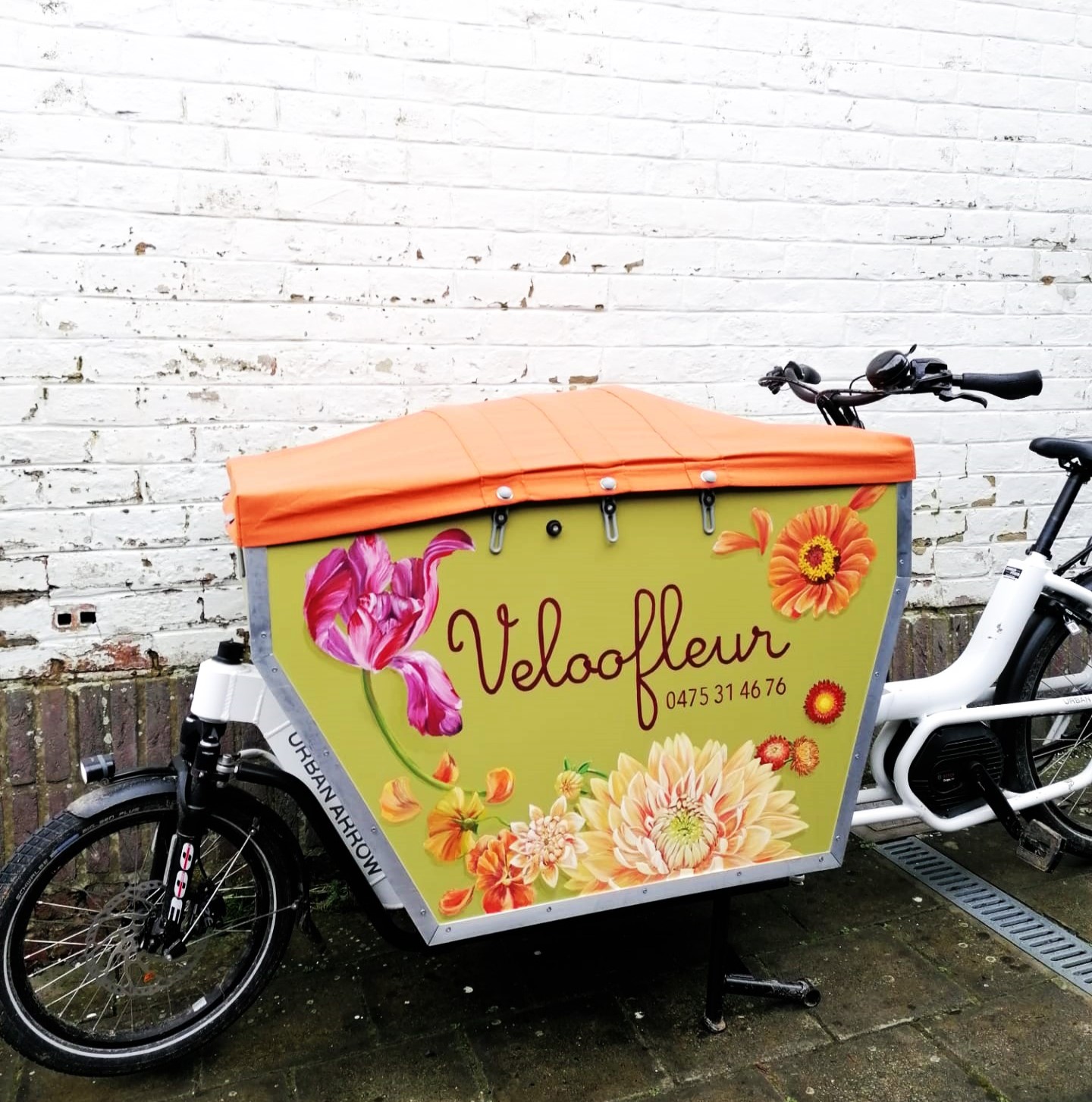 Een bakfiets met een oranje bash